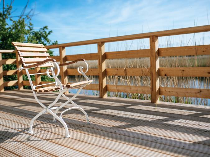 Holzterrasse des Klinikum Schloss Lütgenhof, ein einladender Ort zum Entspannen und Genießen der Natur.