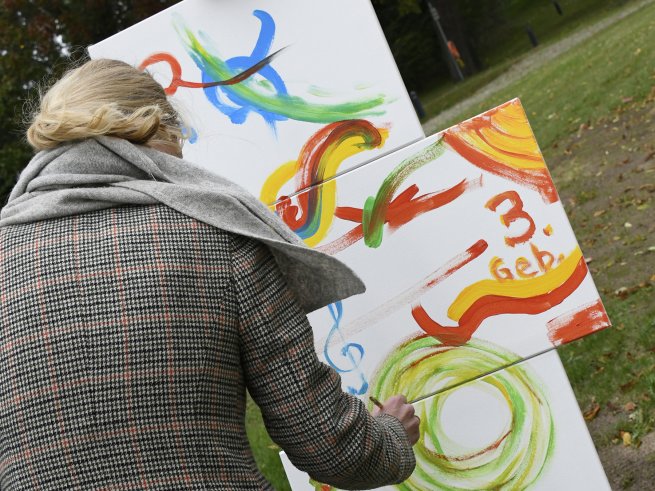 Eine Frau malt an einer Staffelei, um den Geburtstag des Klinikum Schloss Lütgenhof zu feiern.
