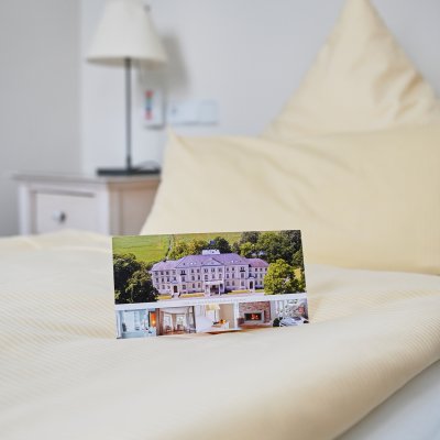Ein gemütliches Klinikzimmer mit einem Bett und einem Infoheft darauf, das zur Entspannung einlädt.