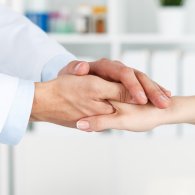 Arzt und Patient reichen sich die Hände nach einer einfühlsamen Behandlung.